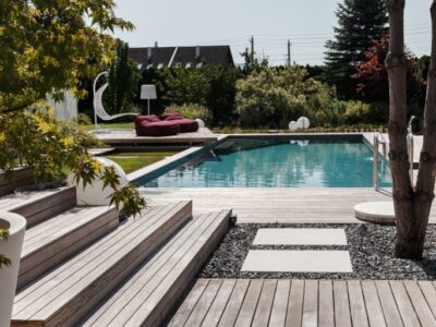 Modern zwembad in strakke designtuin met houten terras